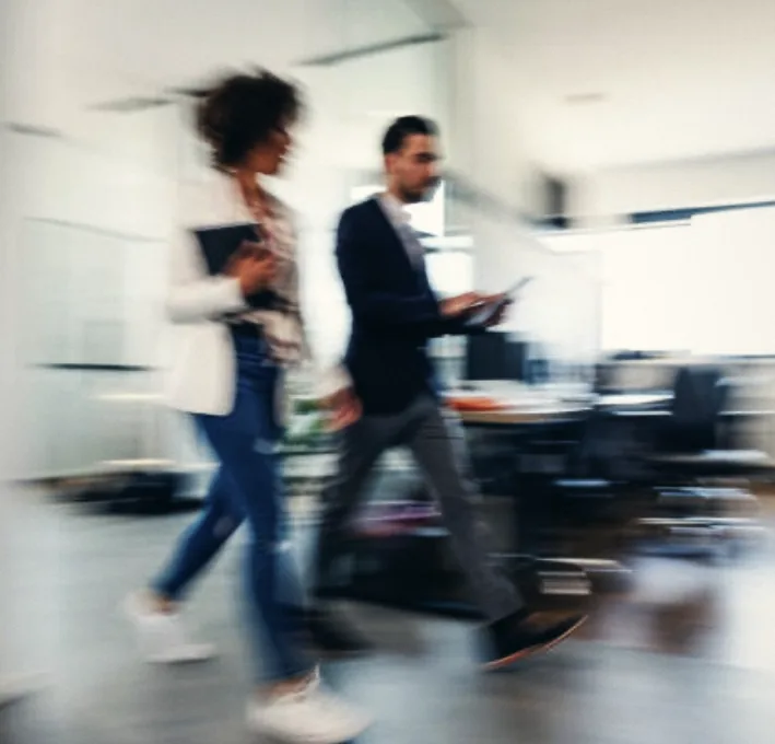 Two colleagues walking through an office